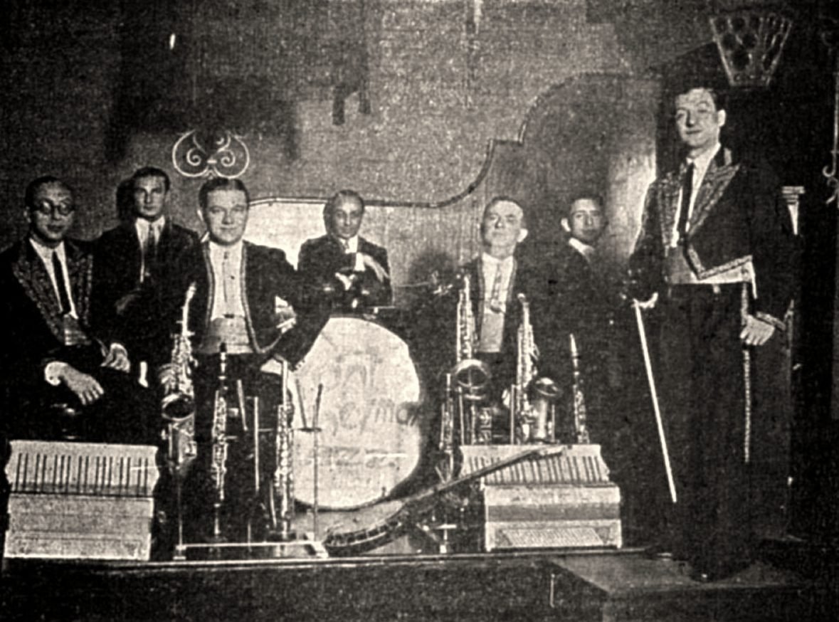 Front-Heyman Jazz Band na estradzie, początek lat trzydziestych. Na wielkim bębnie — nazwa zespołu; po bokach dwa akordeony na stojakach, znak firmowy orkiestry.