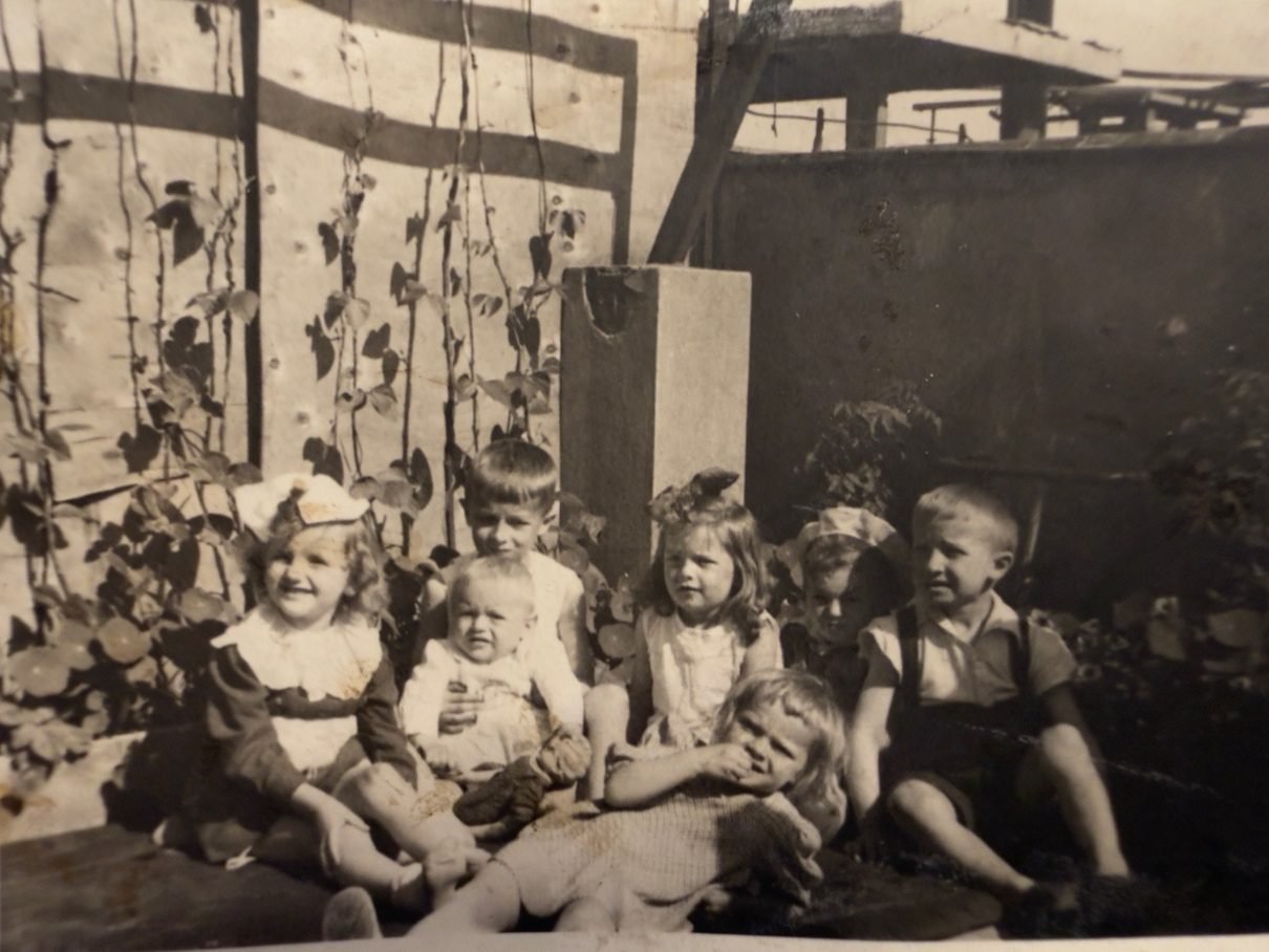 Children of the building at play on the roof of Złota 7 during the occupation; on the left, beans climbing on strings — a wartime crop. From a private collection.