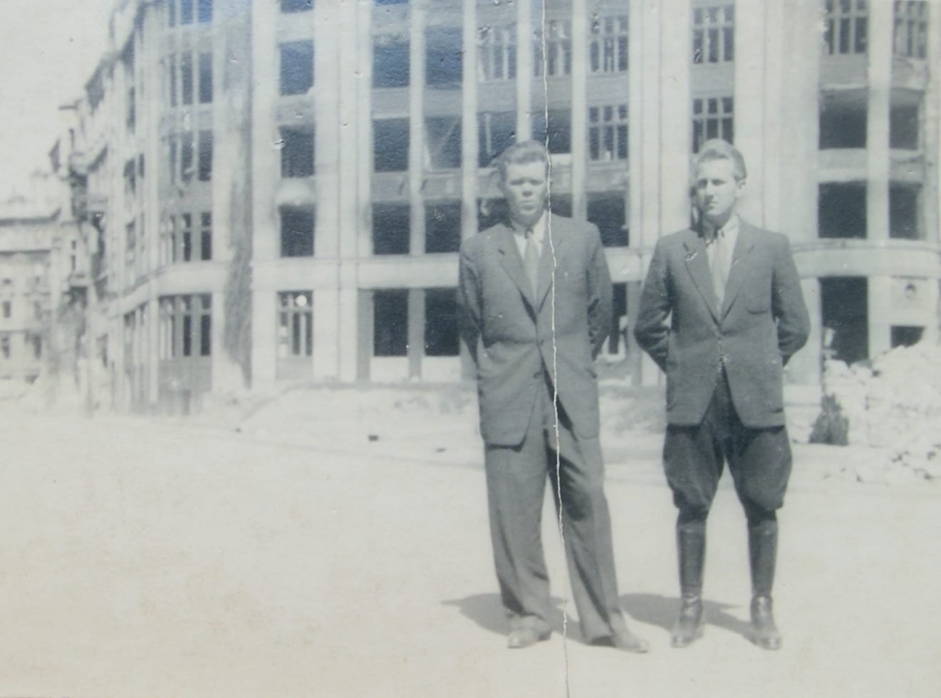 Stanisław Jędrasik (left) in the company of an unidentified man, against a burnt-out building — Warsaw after the war. From a private collection.