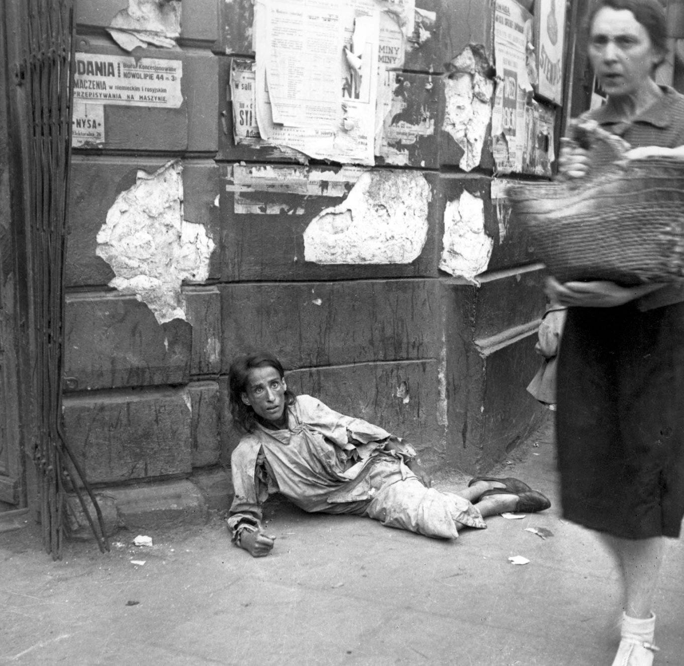 A despairing woman begging in the streets of the Warsaw ghetto, 26 June 1941. The photograph was taken by the German soldier Heinz Hoest