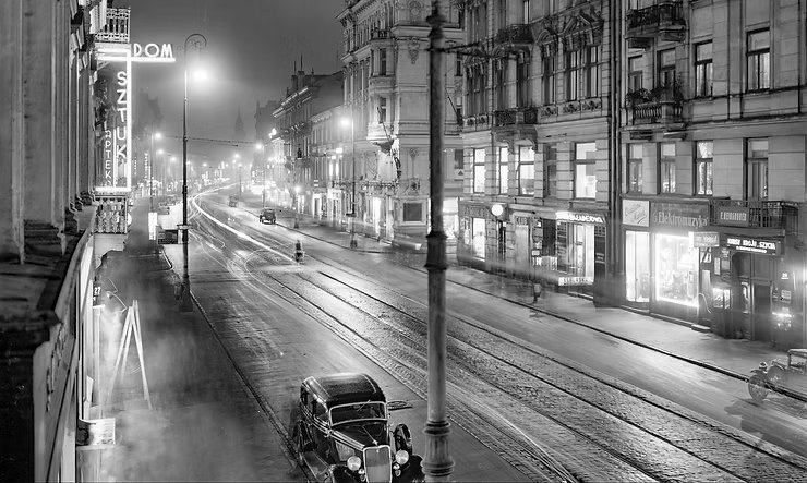 Nowy Świat nocą, 1935. Henryk Poddębski sfotografował ulicę z
balkonu pierwszego piętra kamienicy nr 25, patrząc w stronę placu Trzech
Krzyży; po lewej neon „Dom Sztuki”, po prawej, za latarnią, oświetlony
narożnik Nowego Światu 30 z salonem Jana Zegrze. Muzeum Warszawy, neg.
AN 27570.