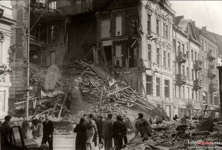 Nowy Świat 30 — róg Foksal po bombardowaniu, październik 1939:
gruz zalega jeszcze chodnik i jezdnię, tłum warszawiaków przy ruinie.
fotopolska.eu.