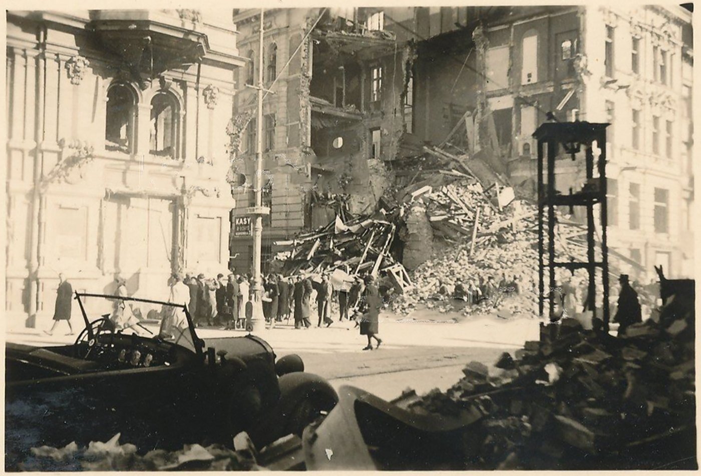 Widok z przeciwnej strony Nowego Światu, jesień 1939, po
uprzątnięciu jezdni: tłum przechodniów na chodniku, na pierwszym planie
rozbity samochód i gruz z drugiej pierzei. Po lewej — gmach z „Kasami”
przy Kopernika 3. fotopolska.eu.