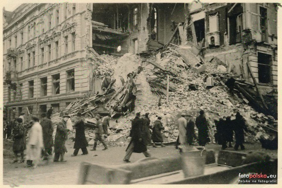 Przechodnie mijają hałdę gruzu przed narożnikiem — ulica drożna,
życie wraca na Nowy Świat. Przełom 1939 i 1940 roku.
fotopolska.eu.